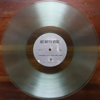 <u>PRESSING INFO</u><br><table class=inf_press><tbody><tr class=inf_info><td class=inf_title>Album:</td><td class=inf_info> Hot Water Music Split on Coke Bottle Clear (Newbury Comics Exclusive)  </td></tr>
    <td class=inf_title>Pressing:</td><td> Ninth Pressing /500  </td></tr>
    <td class=inf_title>Release Date:</td><td> Apr. 7th 2023  </td></tr>
    <td class=inf_title>Album Pressed:</td><td> 2023  </td></tr>
    <td class=inf_title>Label:</td><td> Jade Tree Records JT1067 82119-1  </td></tr>
    <td class=inf_title>Insert:</td><td> Printed Glossy Inner Sleeve  </td></tr>
    <td class=inf_title>Barcode:</td><td> 0 45778-21191 3  </td></tr>
    <td class=inf_title>Side A Matrix:</td><td> EPTÂ·82119Â·1Â·A SAFF  </td></tr>
    <td class=inf_title>Side B Matrix:</td><td> EPTÂ·82119Â·1Â·B SAFF  </td></tr>
    <td class=inf_title>&nbsp;</td><td> <a href=https://www.discogs.com/release/26730758 target=_blank rel=noopener noreferrer>View This Release on Discogs</a>  </tr></tbody></table>
<br><u>PRICING</u><span class='less' style='padding-left: 8px; color: var(--font-colour_grey);'>(prices shown in USD)</span><br><table class='inf_press'><tbody><tr class='inf_info'>
            <td class='inf_title'>Last Sold:</td>
            <td>$10.00 (Jun 29, 2026)</td>
            </tr><tr class='inf_info'>
            <td class='inf_title'>History:</td>
            <td>
                <span class='price-low' title='Sold on Jun 29, 2026'>Low: <span class='price-value'>$10.00</span></span>
                <span class='price-separator'>|</span>
                <span class='price-avg'>Avg: <span class='price-value'>$16.20</span></span>
                <span class='price-separator'>|</span>
                <span class='price-high' title='Sold on Jul 21, 2024'>High: <span class='price-value'>$30.00</span></span>
            </td>
            </tr></tbody></table><br>    <br><br><u>TRACKLIST</u><br><table class='inf_tracks'><tbody><tr>
            <td class='inf_num'>A1</td>
            <td class='inf_trk'>Alkaline Trio - Queen Of Pain</td>
            <td class='inf_len'>3:57</td>
            <td><a href='#' class='lyric-link' data-album-code='splits' data-song-title='Alkaline Trio - Queen Of Pain'>Lyrics</a></td></tr><tr>
            <td class='inf_num'>A2</td>
            <td class='inf_trk'>Alkaline Trio - While You’re Waiting</td>
            <td class='inf_len'>4:07</td>
            <td><a href='#' class='lyric-link' data-album-code='splits' data-song-title='Alkaline Trio - While You’re Waiting'>Lyrics</a></td></tr><tr>
            <td class='inf_num'>A3</td>
            <td class='inf_trk'>Alkaline Trio - Rooftops</td>
            <td class='inf_len'>2:15</td>
            <td><a href='#' class='lyric-link' data-album-code='splits' data-song-title='Alkaline Trio - Rooftops'>Lyrics</a></td></tr><tr>
            <td class='inf_num'>B1</td>
            <td class='inf_trk'>Hot Water Music - God Deciding</td>
            <td class='inf_len'>2:37</td>
            <td><a href='#' class='lyric-link' data-album-code='splits' data-song-title='Hot Water Music - God Deciding'>Lyrics</a></td></tr><tr>
            <td class='inf_num'>B2</td>
            <td class='inf_trk'>Hot Water Music - Russian Roulette</td>
            <td class='inf_len'>3:25</td>
            <td><a href='#' class='lyric-link' data-album-code='splits' data-song-title='Hot Water Music - Russian Roulette'>Lyrics</a></td></tr><tr>
            <td class='inf_num'>B3</td>
            <td class='inf_trk'>Hot Water Music - Radio</td>
            <td class='inf_len'>4:12</td>
            <td><a href='#' class='lyric-link' data-album-code='splits' data-song-title='Hot Water Music - Radio'>Lyrics</a></td></tr><tr>
            <td class='inf_num'>B4</td>
            <td class='inf_trk'>Hot Water Music - Bleeder</td>
            <td class='inf_len'>3:13</td>
            <td><a href='#' class='lyric-link' data-album-code='splits' data-song-title='Hot Water Music - Bleeder'>Lyrics</a></td></tr></tbody></table><br><br>
    <u>NOTES</u><br> Printed inner sleeve (Heavier cardstock and slightly glossier finish compared to 1st presses)
 - B